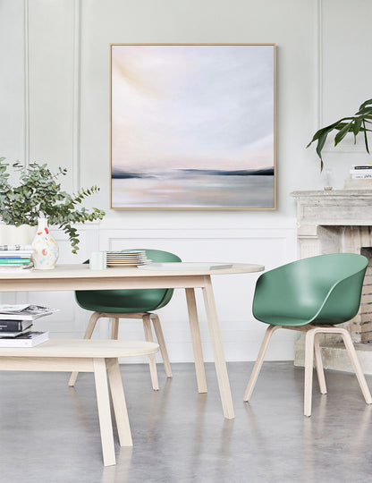 May include: A light wood dining table with a light wood bench and four green chairs. A painting of a landscape with a light blue sky and a horizon line is hanging on the wall behind the table.