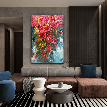 May include: A large abstract painting of a bouquet of pink flowers with green leaves against a blue and white background. The painting is framed and hanging on a wall in a living room.
