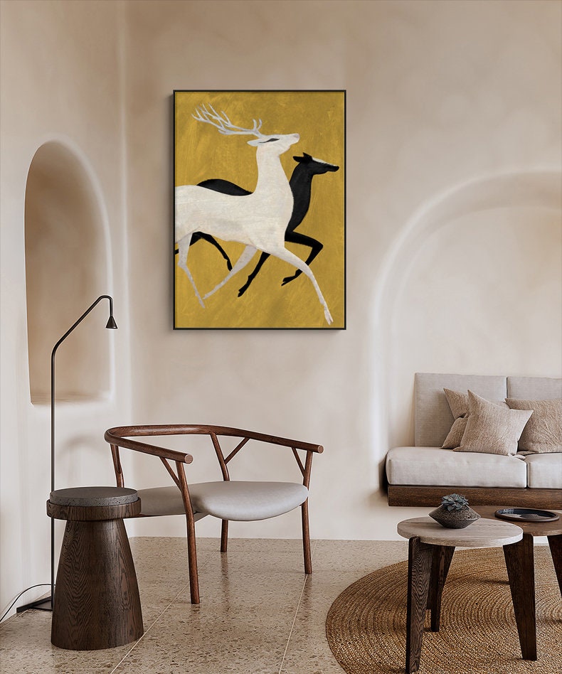 May include: A minimalist painting of two deer running on a gold background. The deer are stylized and simplified, with the front deer in white and the back deer in black.