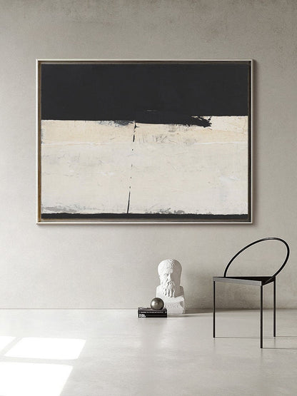 May include: Abstract painting with black and white paint on a canvas. The painting is framed and hanging on a white wall. A white bust of a man is on a shelf below the painting.