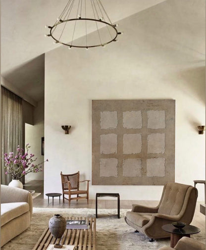 May include: A living room interior with a large abstract painting on the wall, a brown leather armchair, a wooden coffee table, and a white couch. The room is decorated in a minimalist style with neutral colors.
