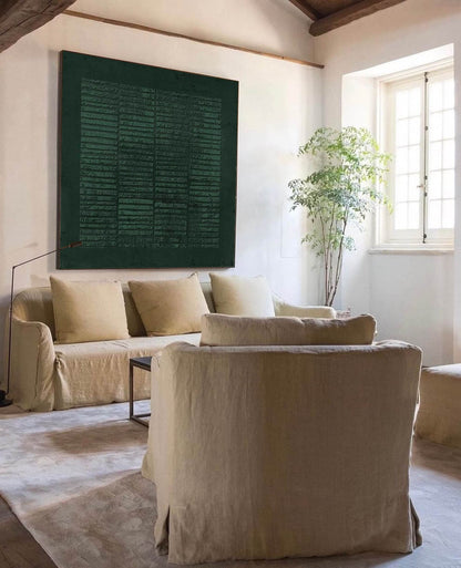 May include: A living room with a large green abstract painting on the wall, a beige sofa with pillows, and a beige armchair. The room has a wooden beam ceiling and a large window with white blinds.