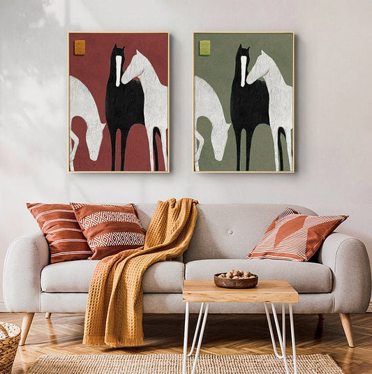 May include: Two framed abstract paintings of three horses in black, white, and grey. The horses are standing close together, with their heads touching. The background of the paintings is a solid color, one red and one green.