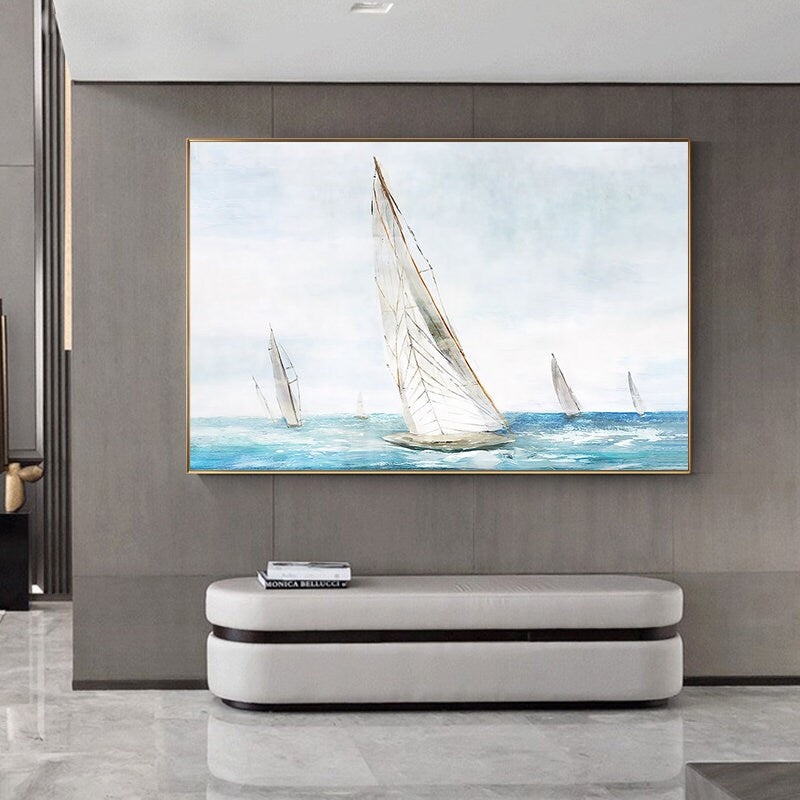 May include: A watercolor painting of sailboats on a blue ocean. The painting is framed in a gold frame and hangs on a gray wall.