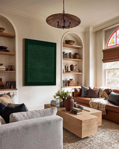 May include: A living room with a light brown couch, a light gray couch, a wooden coffee table, and a green abstract painting on the wall. The room has a woven rug, a wicker lampshade, and a bookshelf with decorative items.