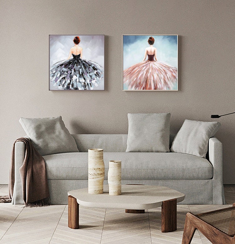 May include: Two framed paintings of women in flowing dresses. The woman in the left painting is wearing a black dress with a gray background. The woman in the right painting is wearing a pink dress with a blue background.