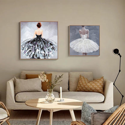 May include: Two framed paintings of ballerinas wearing tutus. The ballerina on the left is wearing a black tutu and the ballerina on the right is wearing a white tutu. Both ballerinas are facing away from the viewer.
