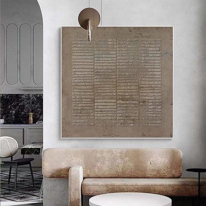 May include: A square wall art piece featuring a textured, monochromatic taupe surface with a repeating pattern of horizontal, raised rectangular bars arranged in vertical columns, framed in a thin white border and mounted on a light gray wall.