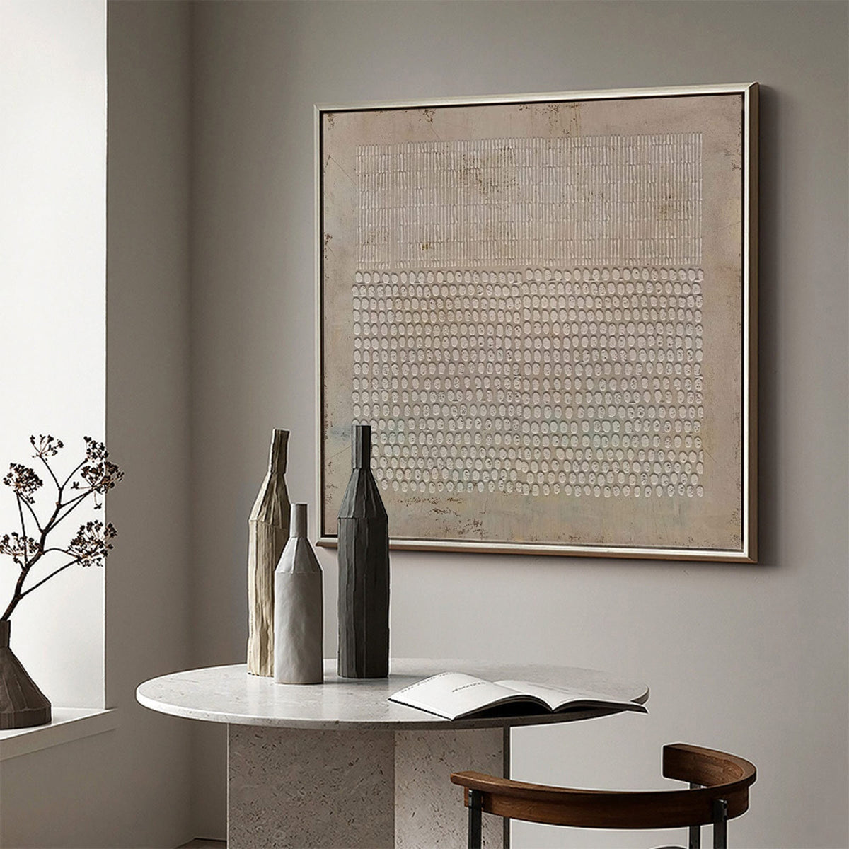 May include: A square framed wall art piece featuring a beige textured background with a top section of vertical white lines and a bottom section of repeating white oval shapes. The artwork is displayed in a thin metallic frame on a neutral wall.