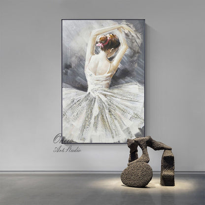 May include: A painting of a ballerina in a white tutu, with her arms raised above her head. The background is a soft gray with white and black brushstrokes. The painting is framed in black.