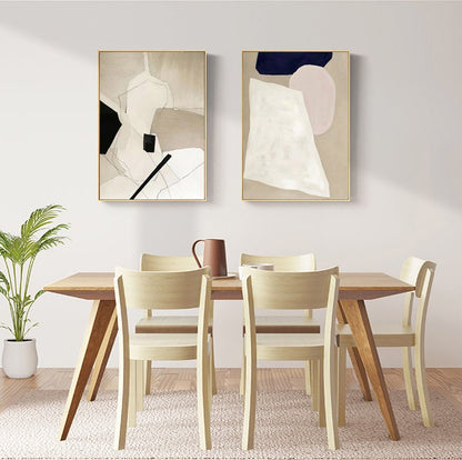 May include: Two abstract paintings with geometric shapes in shades of beige, white, black, and pink, hanging above a wooden dining table with four light wood chairs.