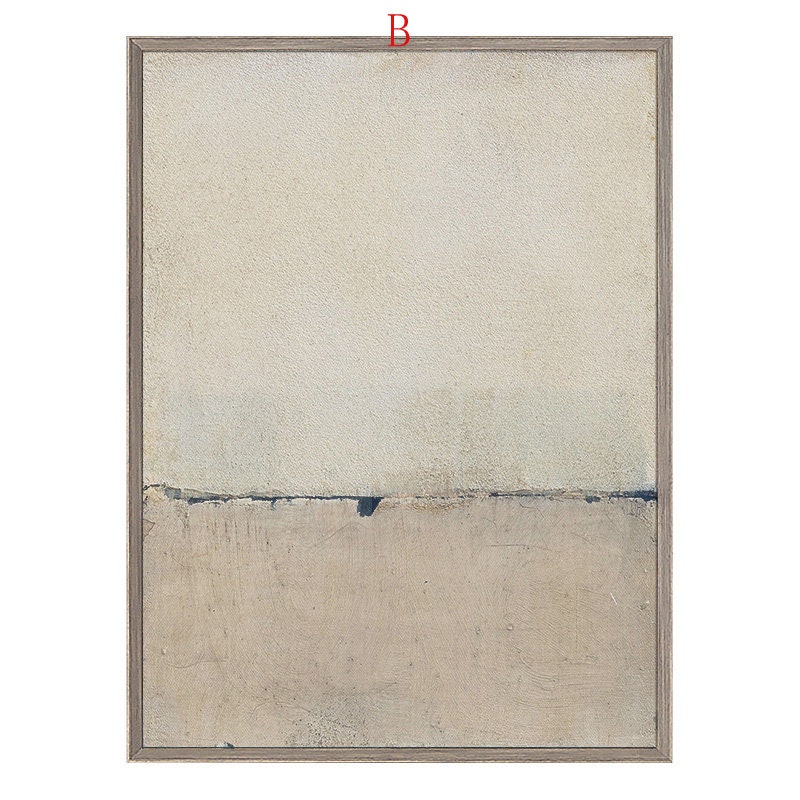 May include: Abstract art print with a beige and gray color scheme. The print features a horizontal line dividing the canvas into two sections. The top section is a lighter beige, while the bottom section is a darker gray. The print is framed in a light wood frame.