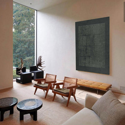 May include: A modern living room with a large window overlooking a green landscape. The room features a large abstract artwork, two wooden chairs with woven backs, and a long wooden bench. Two black side tables and a sofa complete the space.