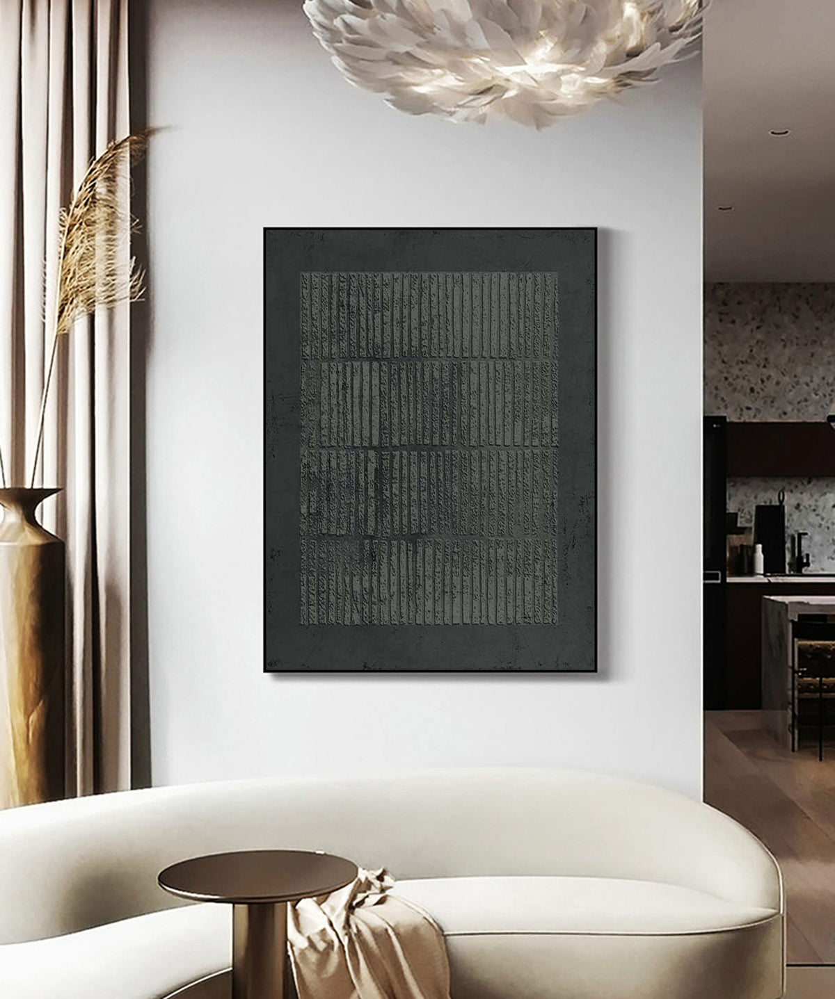 May include: A large, framed abstract art piece with a dark gray textured surface and vertical lines. The artwork is displayed on a white wall above a white sofa, with a brown side table and a decorative vase.