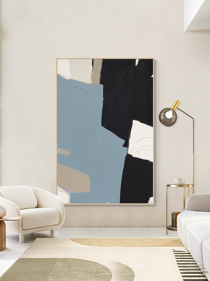 May include: Abstract art print with a blue, black, and beige color scheme. The print is framed in a light wood frame and hangs on a white wall.
