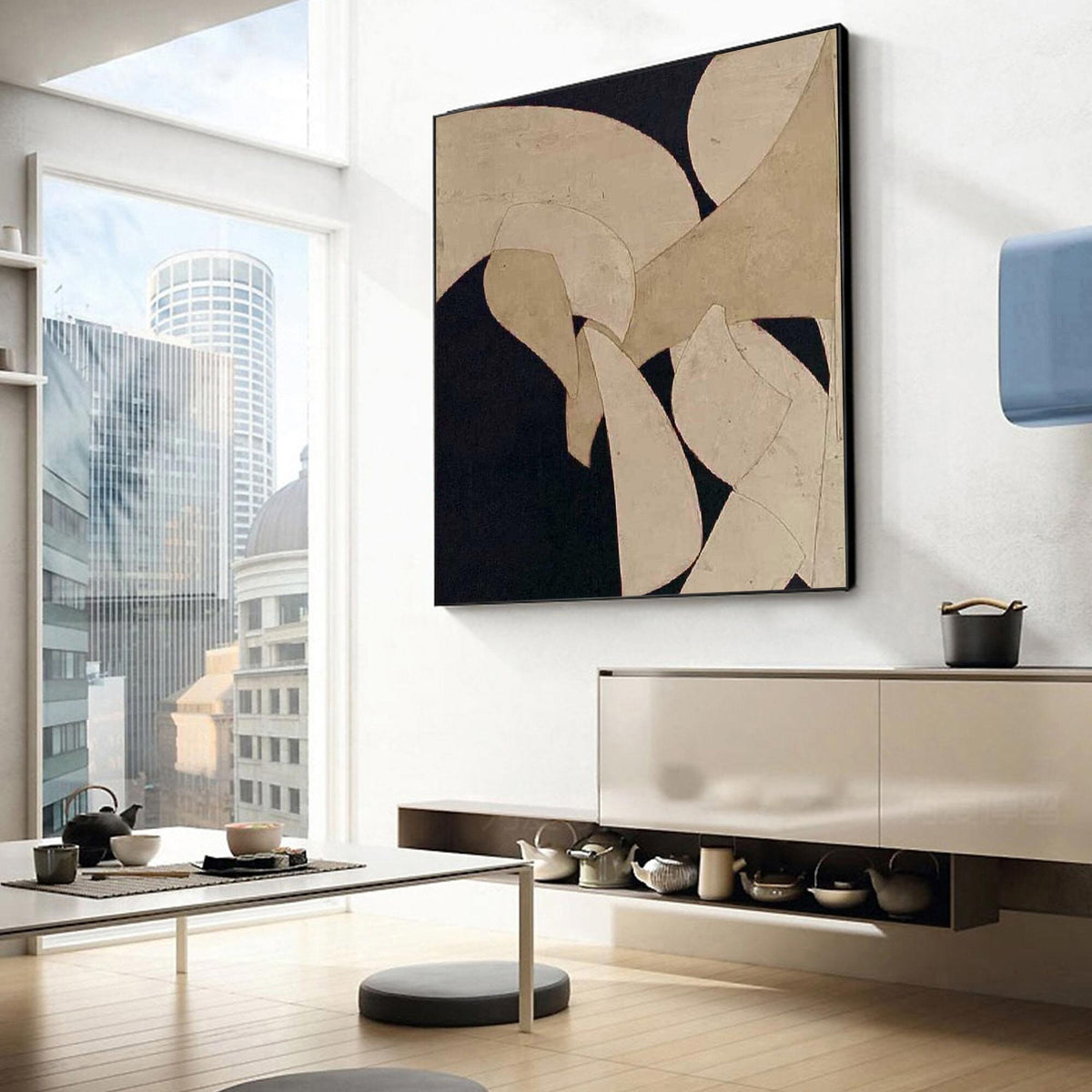 May include: Abstract art piece with a black background and beige geometric shapes. The artwork is framed in black and hangs on a white wall. The room has a modern design with a city view through a large window.