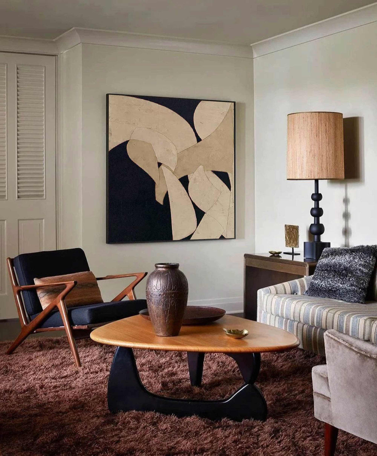 May include: A mid-century modern living room with a brown shag rug, a wooden coffee table, and a black armchair. A large abstract painting hangs on the wall. A tall lamp with a woven shade and a decorative vase are also present.