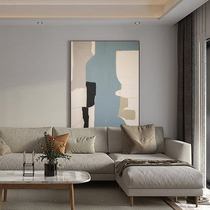 May include: A light gray sectional sofa with a brown throw blanket and pillows. The sofa is in front of a light gray wall with an abstract painting in a black frame.