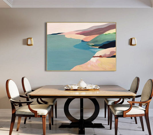 May include: A dining room with a wooden table and chairs. A framed abstract painting of a landscape with a beach and water in shades of blue, green, pink, and brown hangs on the wall.