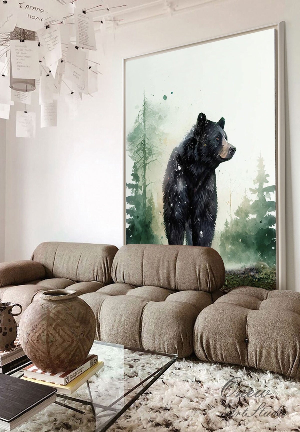 May include: A watercolor painting of a black bear standing in a forest. The bear is facing to the right and has a white patch on its chest. The background is a soft green and blue watercolor wash.