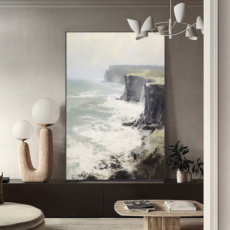 May include: A painting of a seascape with white waves crashing against a rocky cliff. The painting is in a modern, minimalist style and is framed in a black frame.