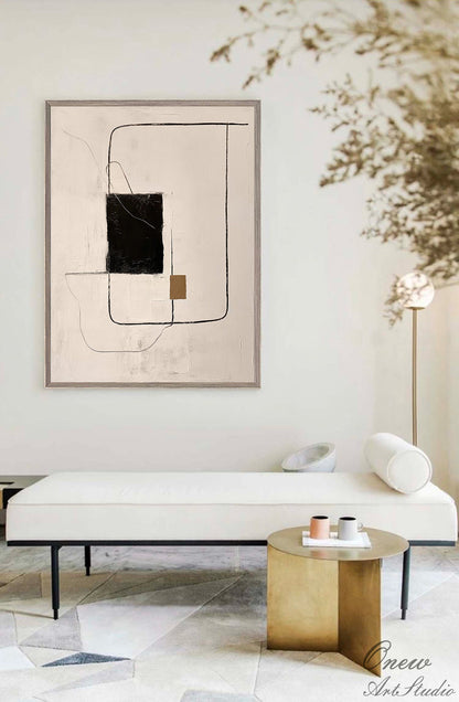 May include: Abstract art painting with black, brown, and white lines and shapes on a beige background. The painting is framed in a light brown frame and is hanging on a white wall.