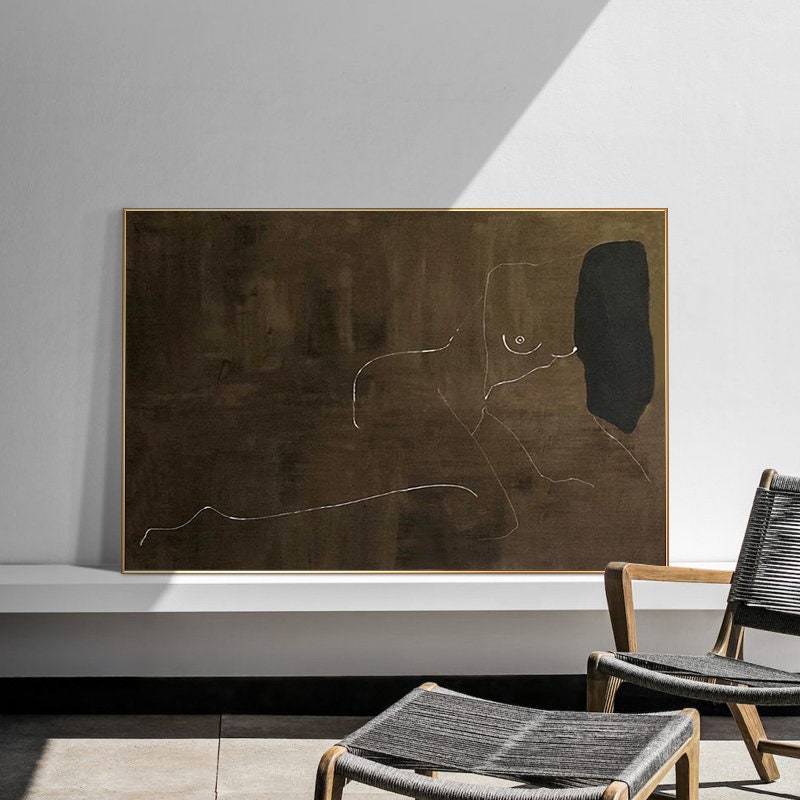 May include: Abstract line drawing of a nude figure in white on a brown background with a black shape in the upper right corner. The artwork is framed in a thin gold frame.