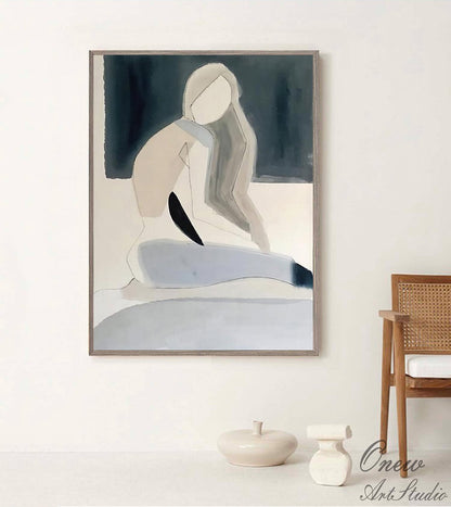 May include: Abstract painting of a person in a seated pose with a blue, white, and gray color scheme. The painting is framed in a light wood frame.