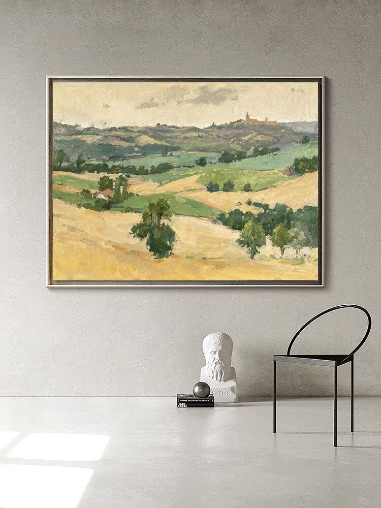 May include: An oil painting of a rural landscape with rolling hills, fields, and trees. The artwork is framed in a dark wood frame and hangs on a light gray wall. The color palette includes shades of yellow, green, and brown.