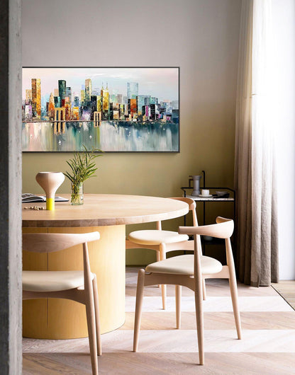 May include: A round wooden dining table with a light wood finish and a cylindrical base. Four light wood chairs with beige cushions surround the table. A painting of a cityscape with a bridge in the foreground hangs on the wall behind the table.