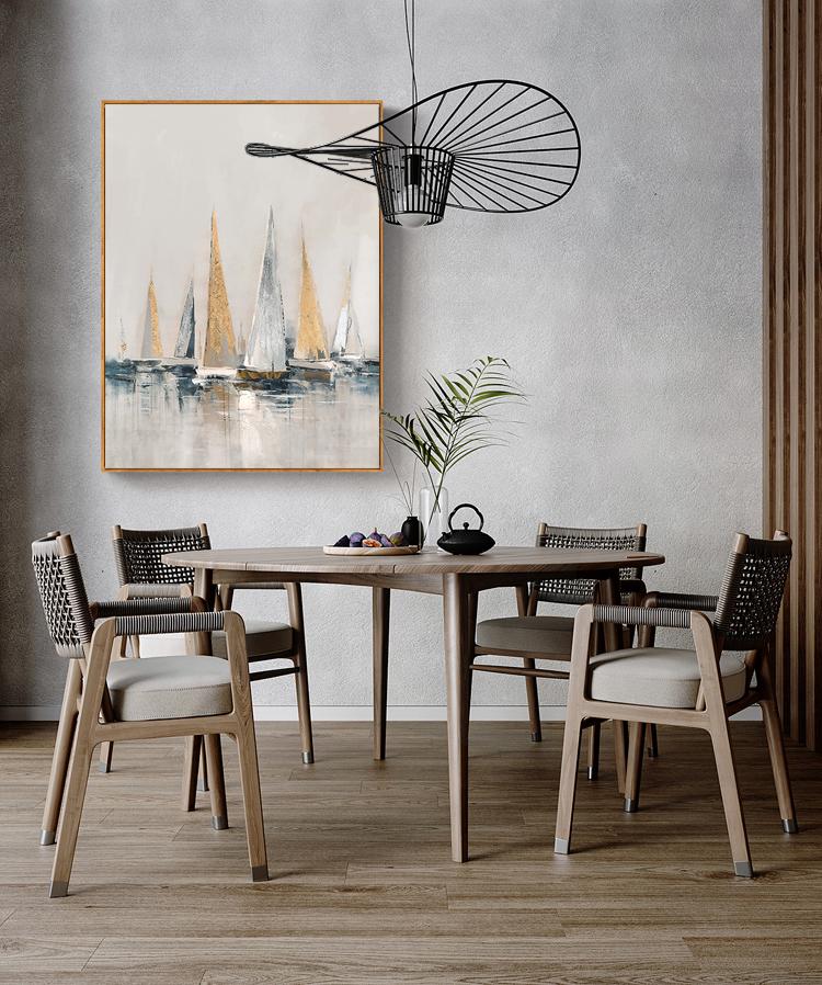 May include: A dining room with a wooden table and chairs. The table has a light wood finish and the chairs have woven seats. A painting of sailboats in shades of blue, white, and gold hangs on the wall above the table. A black metal light fixture hangs from the ceiling.