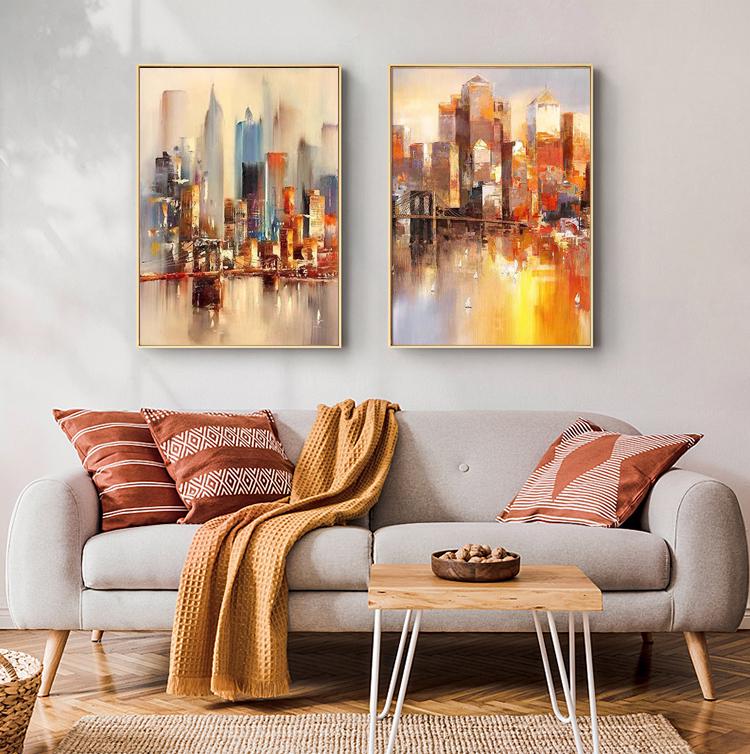 May include: Two abstract paintings of a city skyline with a reflection of the buildings in the water. The paintings are in warm colors, including orange, yellow, and red.