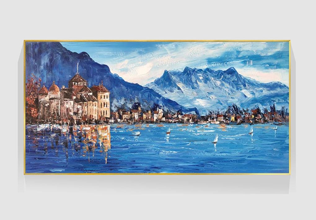 May include: A painting of a town on a lake with mountains in the background. The town is painted in shades of brown and the lake is a deep blue. The mountains are painted in shades of blue and white. There are sailboats on the lake.