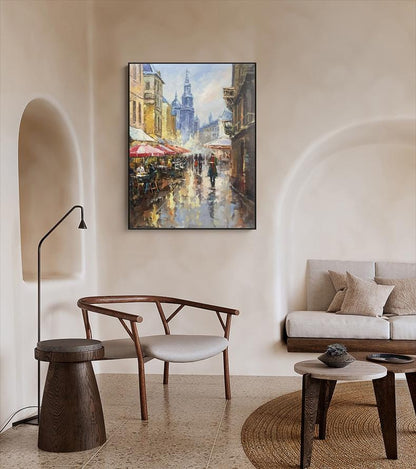 May include: A painting of a European city street scene with buildings, people, and umbrellas. The painting is done in a realistic style with a focus on the details of the architecture and the people.