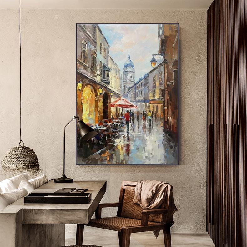 May include: A painting of a European city street scene with a church in the background. The street is lined with buildings and there are people walking on the sidewalk. The painting is done in a realistic style with a focus on detail.