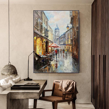May include: A painting of a European city street scene with a church in the background. The street is lined with buildings and there are people walking on the sidewalk. The painting is done in a realistic style with a focus on detail.