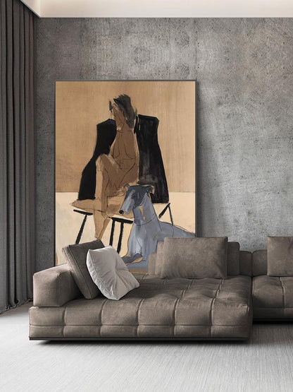 May include: A painting of a person sitting on a chair with a dog beside them. The painting is in a brown frame and is hanging on a gray wall. A brown sectional sofa with white pillows is in the foreground.