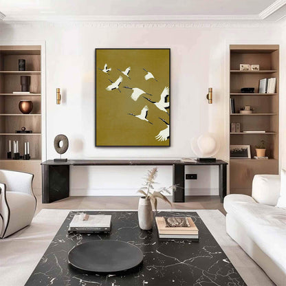 May include: A rectangular wall art print featuring a flock of white cranes with black wingtips and red crowns flying across a solid olive-green background. The birds are depicted in various positions of flight, creating a sense of movement.