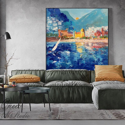 May include: A painting of a coastal town with a sailboat in the foreground. The town is built on a hillside with a mountain in the background. The water is blue and the sky is a bright blue with white clouds. The painting is done in a loose, impressionistic style.