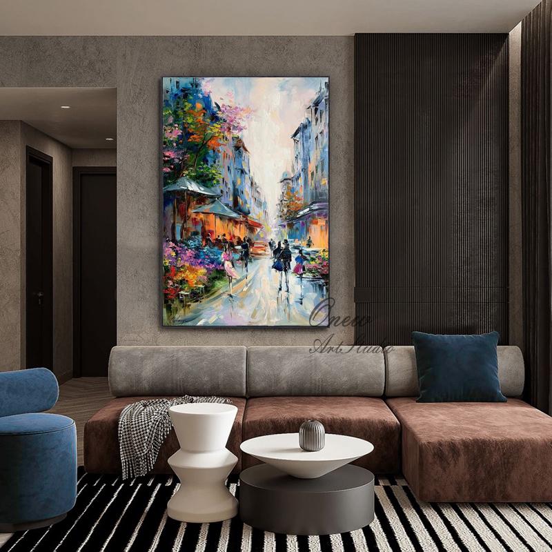 May include: An oil painting depicts a European street scene with colorful buildings, shops, and pedestrians. The artwork features vibrant hues of blue, orange, pink, and green, creating a lively atmosphere. The painting is displayed above a modern sofa in a living room setting.