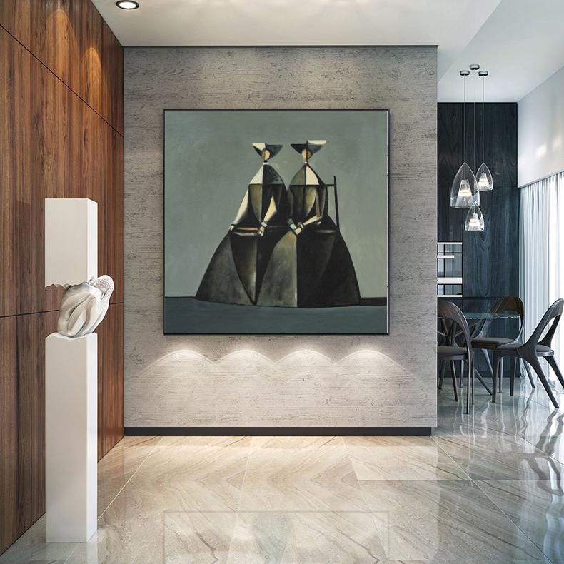 May include: An abstract painting of two figures in dark dresses and hats, set against a muted gray background. The artwork is framed and mounted on a textured wall in a modern interior. The room features wood paneling, a white sculpture, and pendant lights.