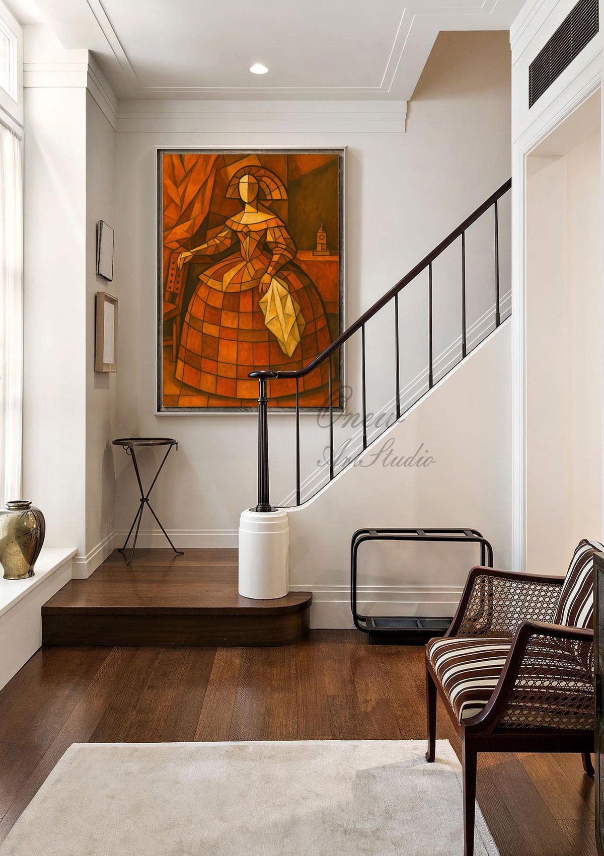 May include: An abstract painting of a woman in a dress, rendered in shades of orange and brown, hangs on a white wall. The artwork is the focal point of a well-lit hallway with a dark wood floor, a staircase, and a decorative chair.