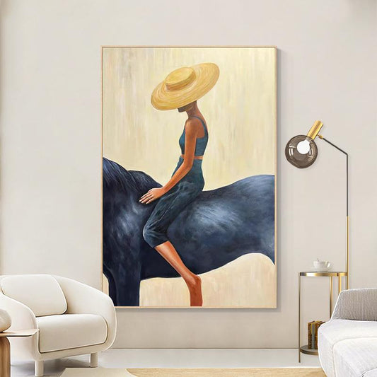May include: An abstract painting depicts a person riding a dark blue horse. The person wears a wide-brimmed yellow hat and a matching blue outfit. The background is a soft, light yellow, and the artwork is framed in a simple, light-colored frame.