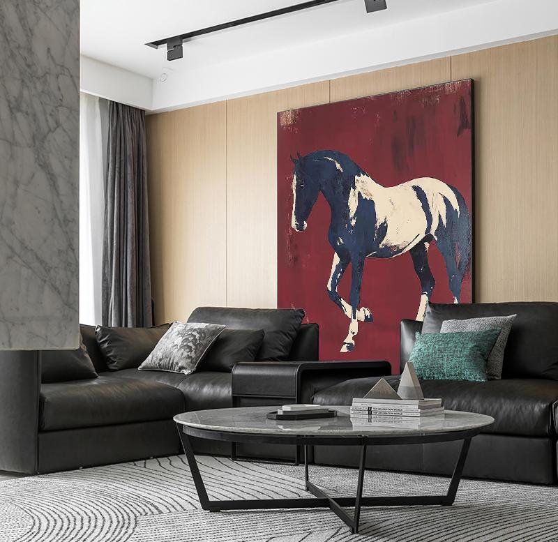 May include: A large abstract painting of a horse in navy blue and cream against a deep red background hangs above a black leather sofa. A round coffee table with a marble top and black metal legs sits in front of the sofa.