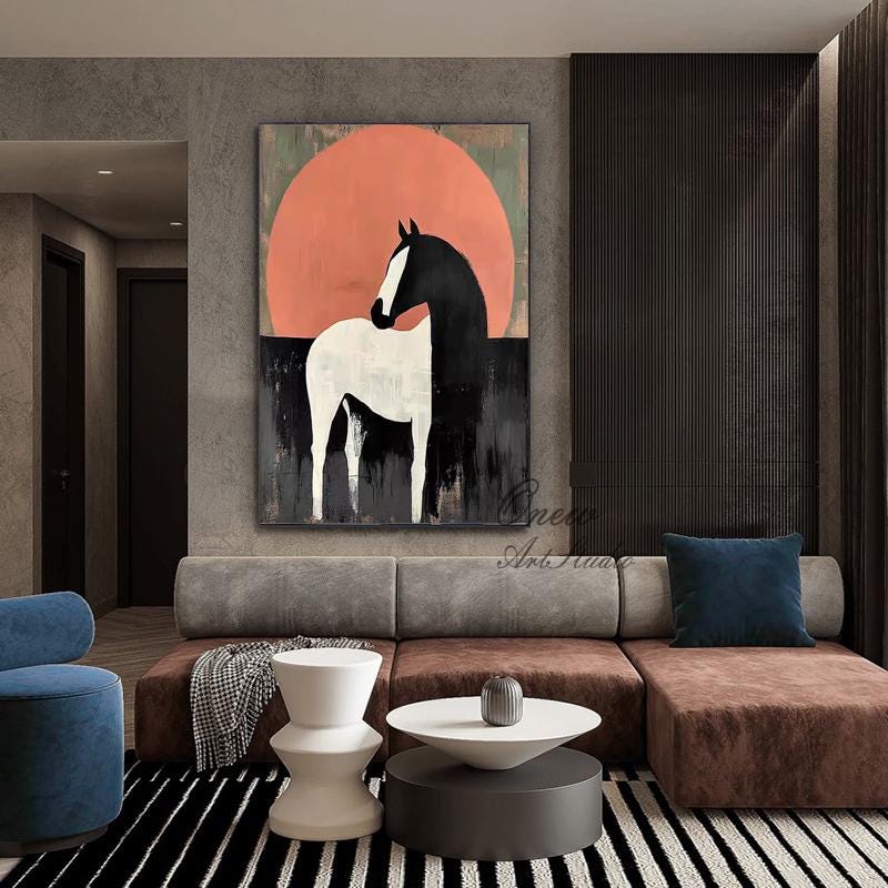 May include: Abstract painting of a horse with a black mane and tail, and a white body, set against a large orange circle and a black background. The artwork is displayed in a modern living room setting.