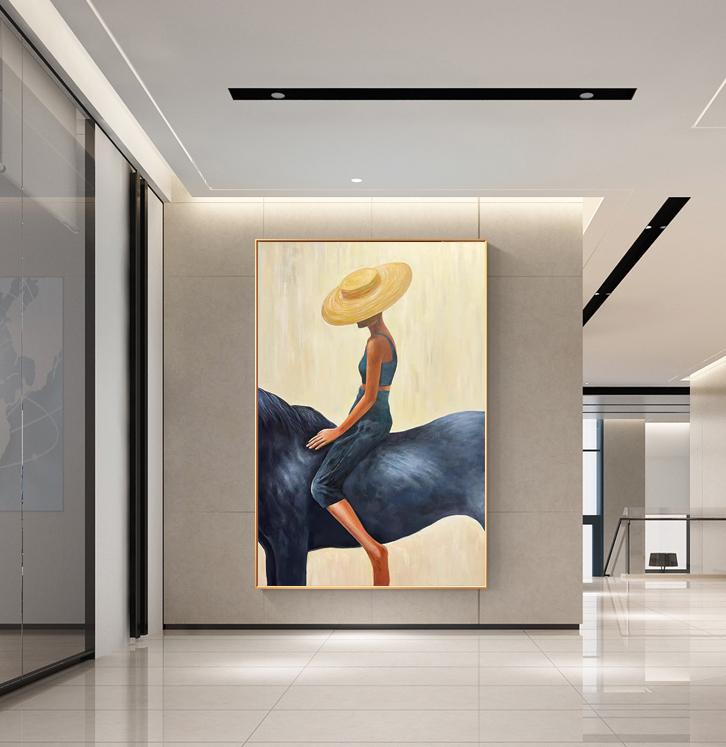 May include: An abstract painting depicts a figure wearing a hat and riding a dark blue horse. The figure is dressed in blue and tan tones, set against a light yellow background. The artwork is framed in a gold-colored border.