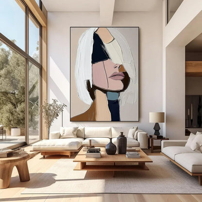 May include: Large abstract painting of a woman's face with a modern aesthetic. The artwork features a palette of white, pink, black, and beige. The woman's face is partially obscured by white brushstrokes, creating a textured effect. The painting is displayed in a modern living room.