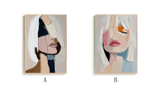 May include: Two abstract portrait paintings. One features a side profile with white hair and a face composed of beige, black, and pink shapes. The other shows a face with closed eyes, pink lips, and orange and pink accents, all in a light wooden frame.