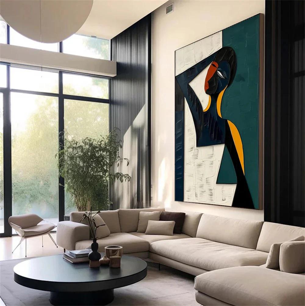 May include: Abstract art piece featuring a figure with a black, white, teal, and yellow color palette. The artwork hangs on a white wall above a beige sectional sofa. A black coffee table and large windows are also visible.