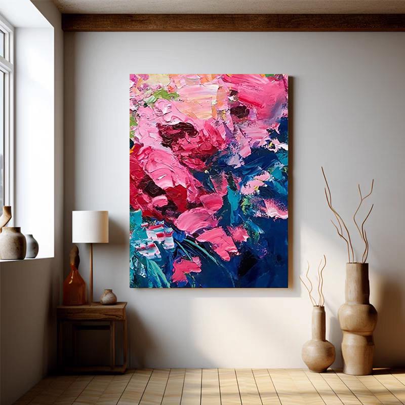 May include: An abstract floral painting with thick brushstrokes in shades of pink, red, and blue. The artwork is displayed on a white wall in a room with wooden floors and decorative vases. A lamp and side table are also visible.